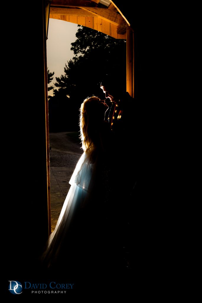 Silhouette of bride and groom in barn 